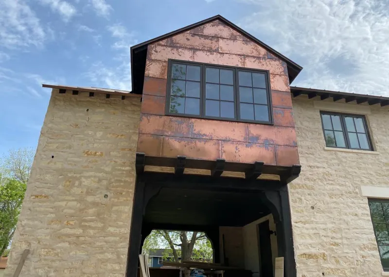 Copper metal panel facade on a stone building for Skylight Installation in Braselton